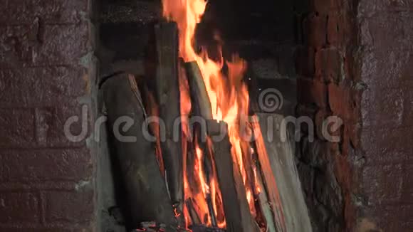 从燃烧在砖火场中的原木中跳跃的明亮火焰慢运动4k视频的预览图