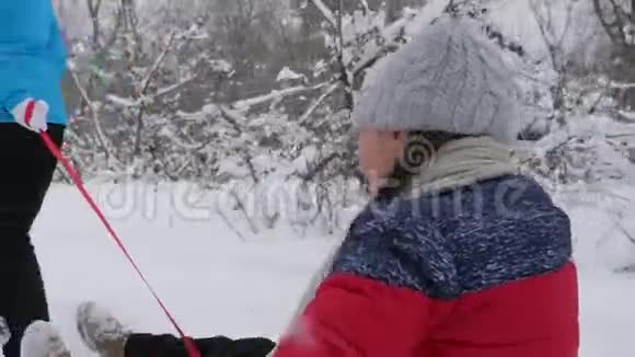 快乐童年理念家庭寒假孩子和母亲在雪地里滑雪女儿和妈妈在冬天玩耍视频的预览图