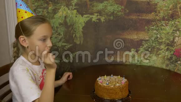 女孩从蛋糕上取出蜡烛女孩从站在桌子上的蛋糕上拿出蜡烛视频的预览图