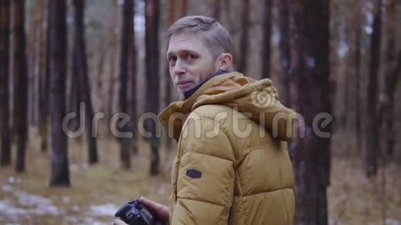穿夹克的人穿过秋天的森林慢动作电影镜头视频的预览图