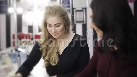 两个漂亮的女孩在美容院和时尚杂志聊天视频的预览图
