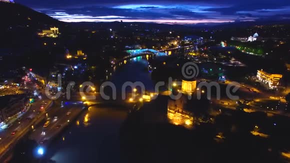 天黑后美丽的河流在明亮的城市桥梁下流动空中拍摄视频的预览图