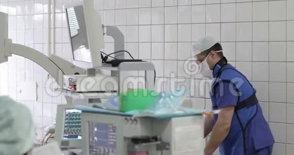 一位穿制服的年轻医生在手术室移动医疗x光设备视频的预览图