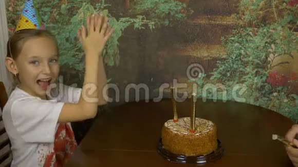 动作快女孩用手拍手坐着的女孩害怕火在蛋糕里喷火喷泉女孩生日视频的预览图