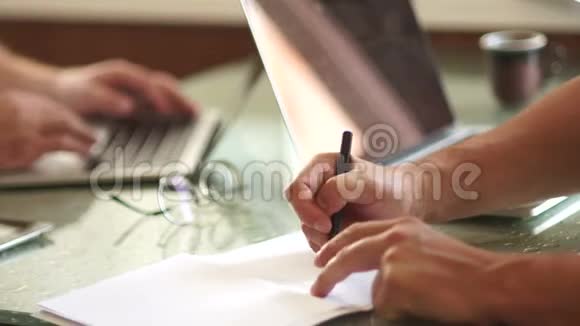 办公室的工作时间特写商人在纸上画一支笔方案同事会议视频的预览图