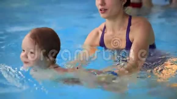 快乐微笑的幼儿在游泳池里跳着在水底下潜水一次水下射击慢动作视频的预览图