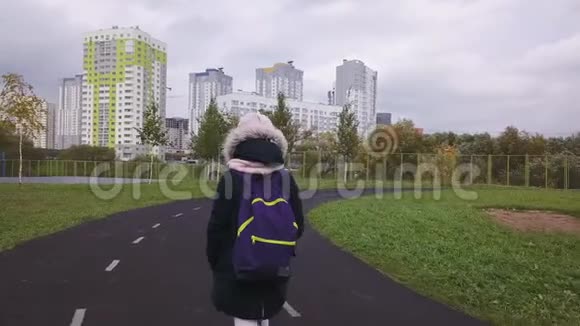 那个女学生在寒冷的秋日通过体育场上学视频的预览图