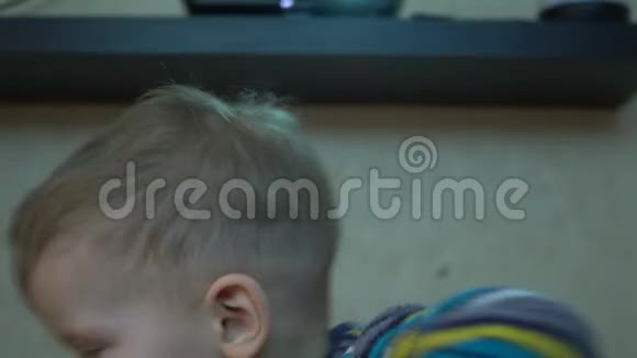 一个两岁的男孩正在家中放映机上看电影视频的预览图