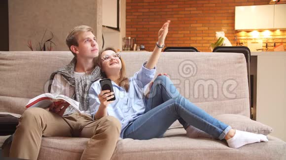 年轻的情侣坐在沙发上计划修理视频的预览图