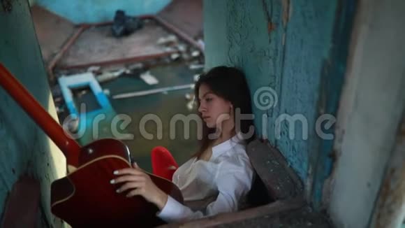 女人坐在旧船里拿着吉他视频的预览图