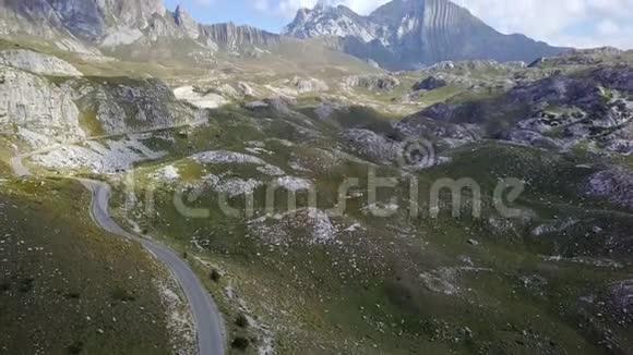 无人驾驶飞机飞越黑山丘陵和田野的两条车道背景是4k的岩石视频的预览图