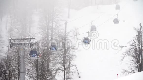 冬季滑雪场山上有滑雪电梯滑雪坡与滑雪电梯和运行在雾天活跃假日视频的预览图
