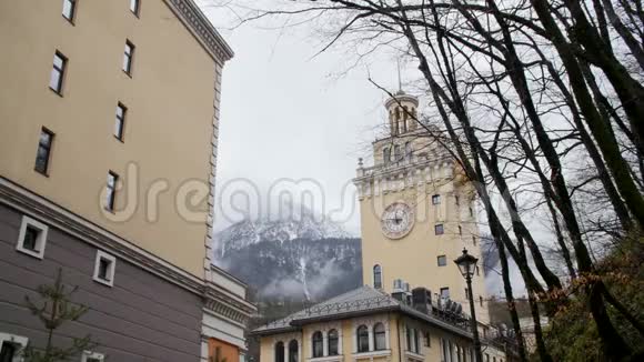 度假小镇和高山雪山峰峦叠嶂度假小镇的小巷可以俯瞰钟楼和背景山脉视频的预览图
