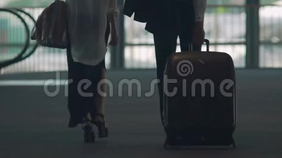 已婚夫妇穿过机场立交桥男子提手提箱度假视频的预览图