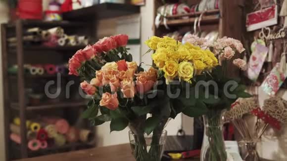 花店里的花瓶里放着美丽的粉红色和黄色的玫瑰视频的预览图