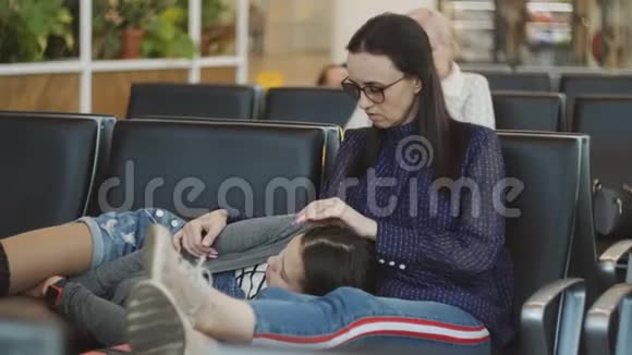 在机场候机室里睡在椅子上的母女视频的预览图