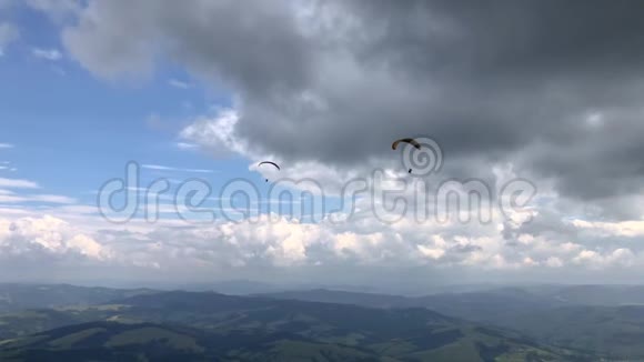 两架滑翔伞在山上的天空中飞行视频的预览图
