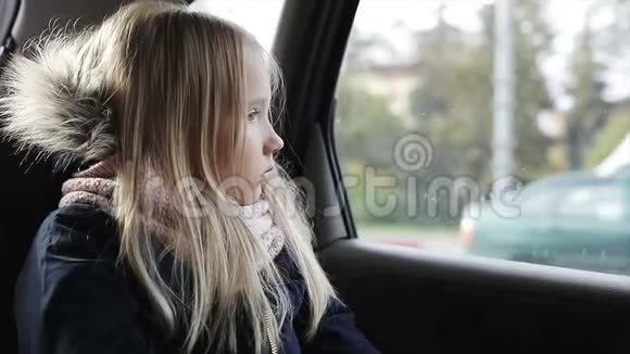 坐在车后座上的金发小女孩视频的预览图