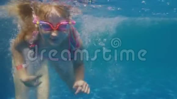 在水疗中心和游泳池里玩得开心六岁女孩学游泳水下视频视频的预览图