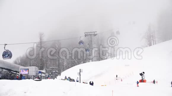 冬季滑雪场山上有滑雪电梯滑雪坡与滑雪电梯和运行在雾天活跃假日视频的预览图