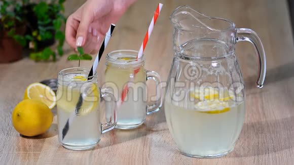 木制背景上的两个梅森罐杯自制柠檬水视频的预览图