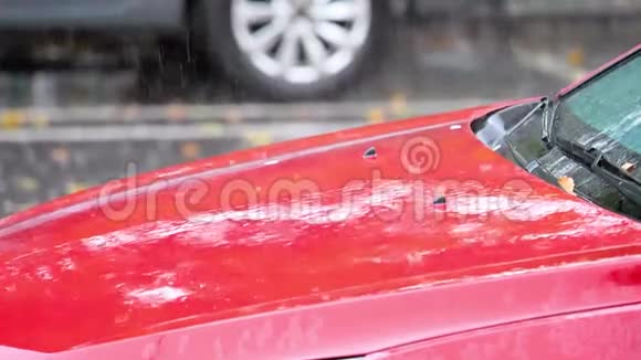 雨水滴落在停车场的红车上在180fps内缓慢运动大雨落下背景视频的预览图