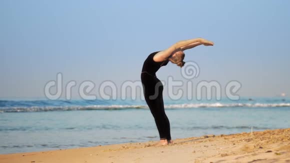 穿着运动服的年轻女子在海边练习普拉提视频的预览图