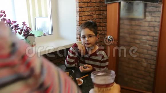 孙子在奶奶家吃加蜂蜜的干酪薄饼视频的预览图