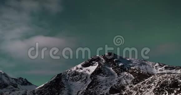 伴随着极光云层星星和山雪的绿色天空的时间流逝视频的预览图