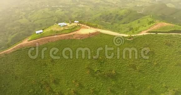空中无人机鸟瞰视频在一座长满绿草的山上在山顶上有一个农场视频的预览图