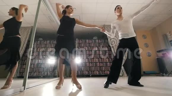 年轻男女穿着服装在工作室里跳舞练习拉丁美洲舞蹈动作缓慢视频的预览图