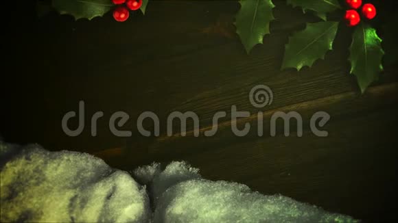 木质背景上的动画特写白雪和绿色圣诞树枝视频的预览图