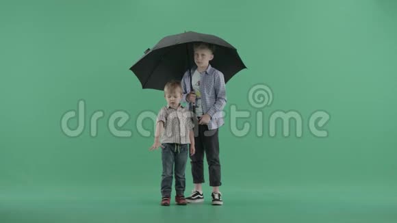 两个孩子拿着伞站着视频的预览图