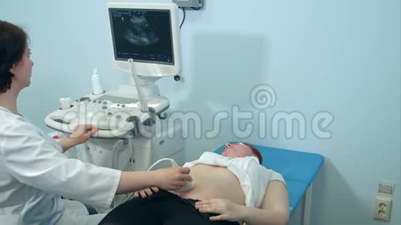 持有超声换能器诊断孕妇病情的女声学家视频的预览图