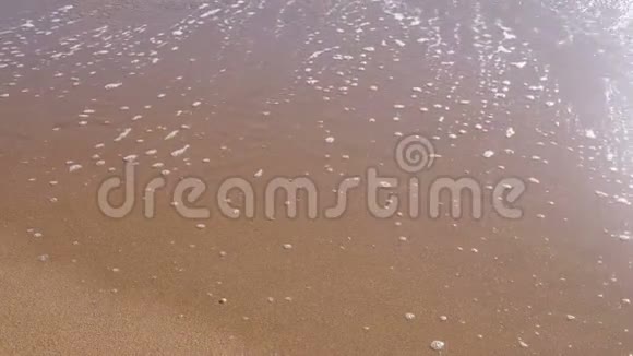 沙滩上有泡沫的软海浪视频的预览图