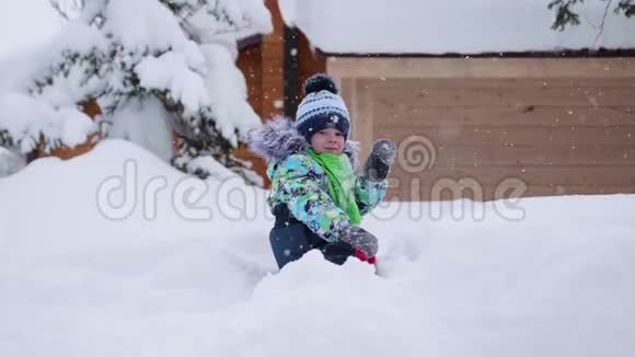 一个小孩子在冬季公园散步在白色蓬松的雪上玩耍和微笑的婴儿主动休息和游戏视频的预览图