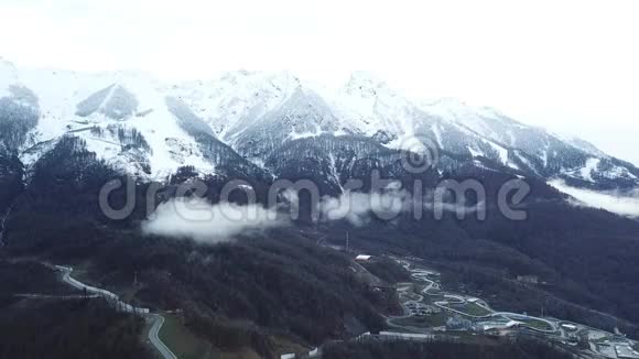 山顶观景度假胜地近山有雪山山脚下的小型滑雪场雾中有雪山视频的预览图