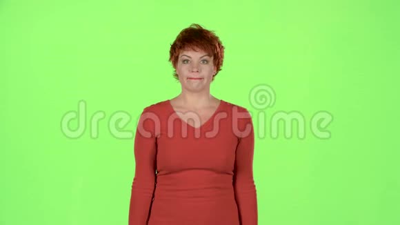 红头发的女人抱着胜利的希望把手指折在怀里绿色屏幕视频的预览图