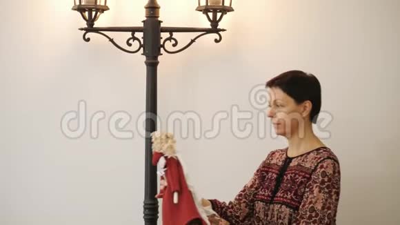 一个女人把一个漂亮的洋娃娃放在椅子上视频的预览图