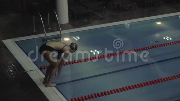 运动女游泳者在空泳池中在清水中潜水慢动作视频的预览图