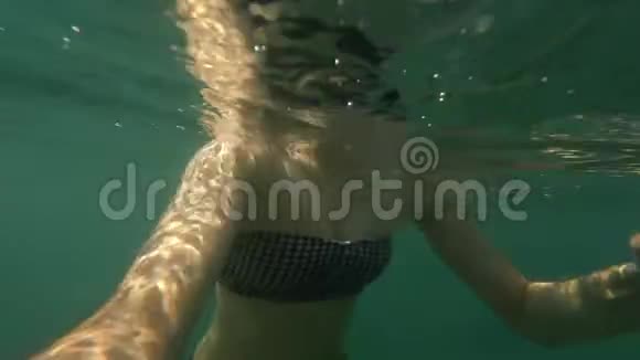 在阳光明媚的日子里带着游泳面具的年轻女子在海水或海水中潜水的水下自拍视频的预览图