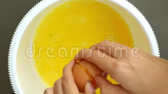 女人的手打破了鸡蛋把它搅拌起来视频的预览图