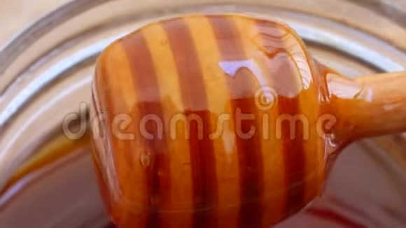 木制蜜盘把蜂蜜倒入罐子里视频的预览图