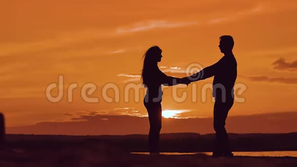 男人和女人纺手剪影男人和女孩幸福的年轻夫妇在外面慢舞视频的预览图