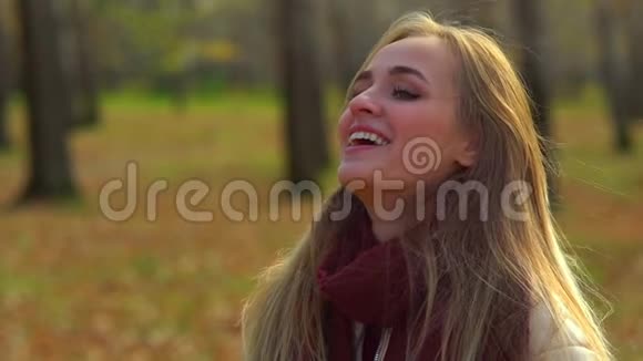 年轻迷人的女孩在秋天公园笑视频的预览图