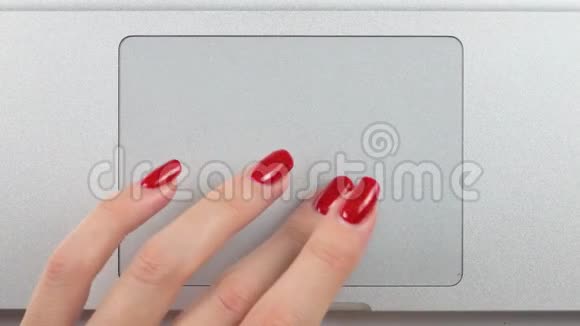 4K镜头女人的左手红色指甲使用和点击一个轨迹板俯视图特写视频的预览图