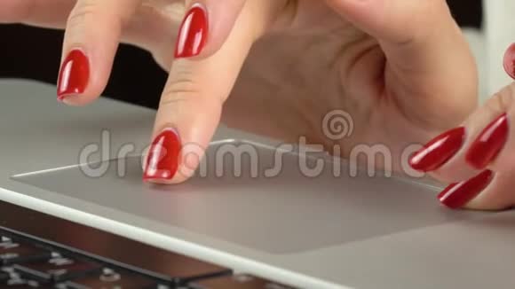 4K镜头女人的手红色指甲使用和点击便携式电脑轨迹板特写视频的预览图