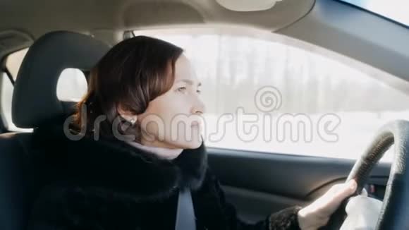 一个穿着黑色皮毛大衣的女人正在开车女孩开车视频的预览图