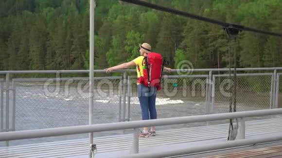 那个带着红色背包的旅行者的女人到过山河的斜拉桥要花钱视频的预览图