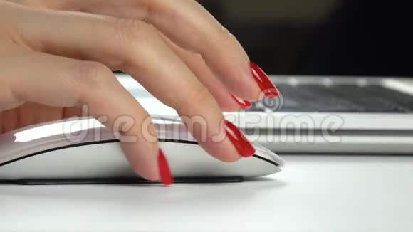 4K镜头女人用无线电脑鼠标红色指甲特写视频的预览图